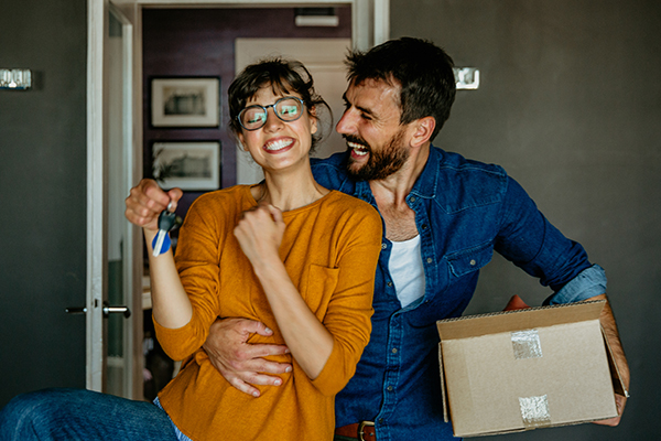 couple with keys and a moving box